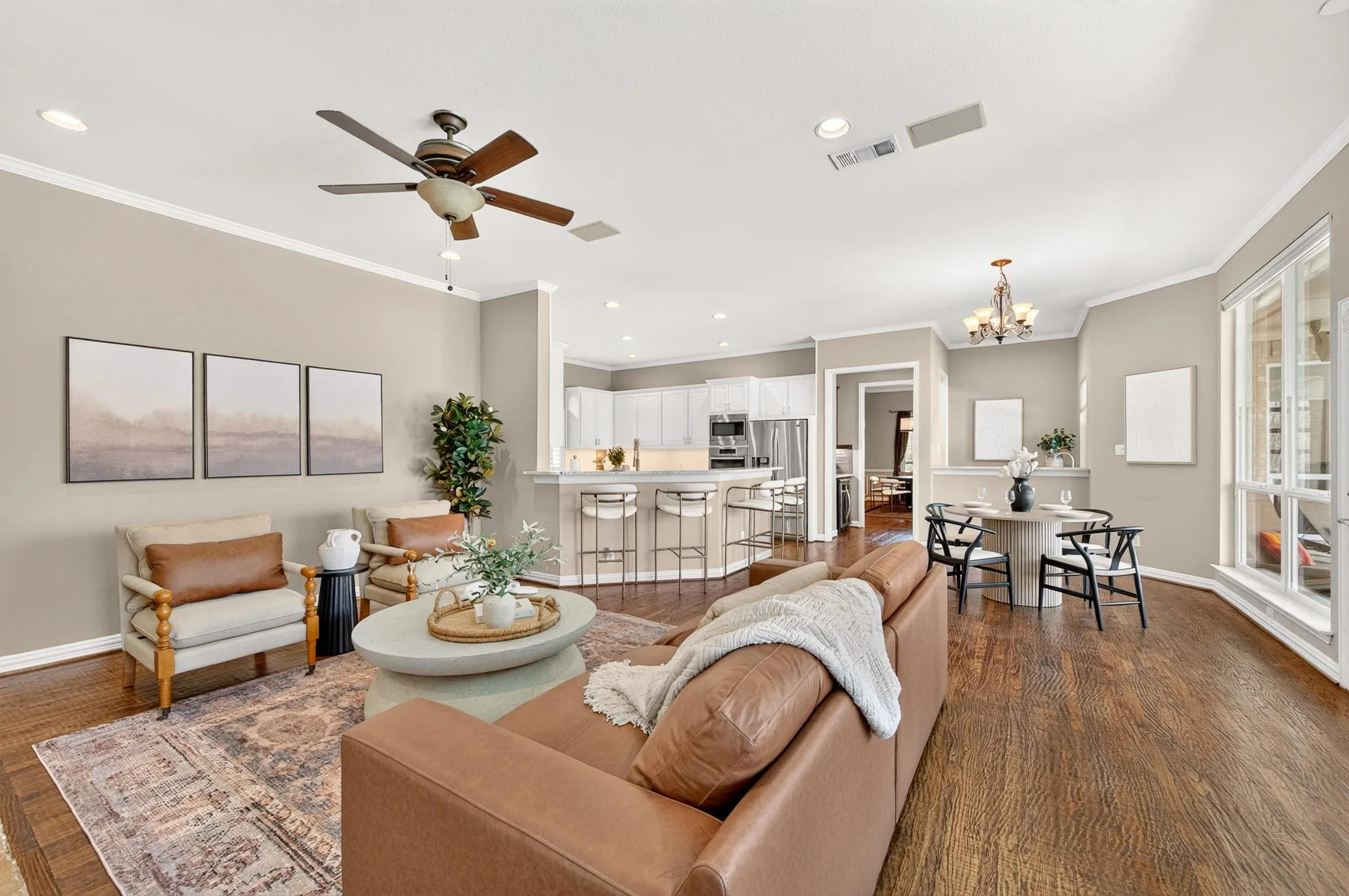 Hardwood flooring, recessed lighting, crown molding, a ceiling fan, and large windows