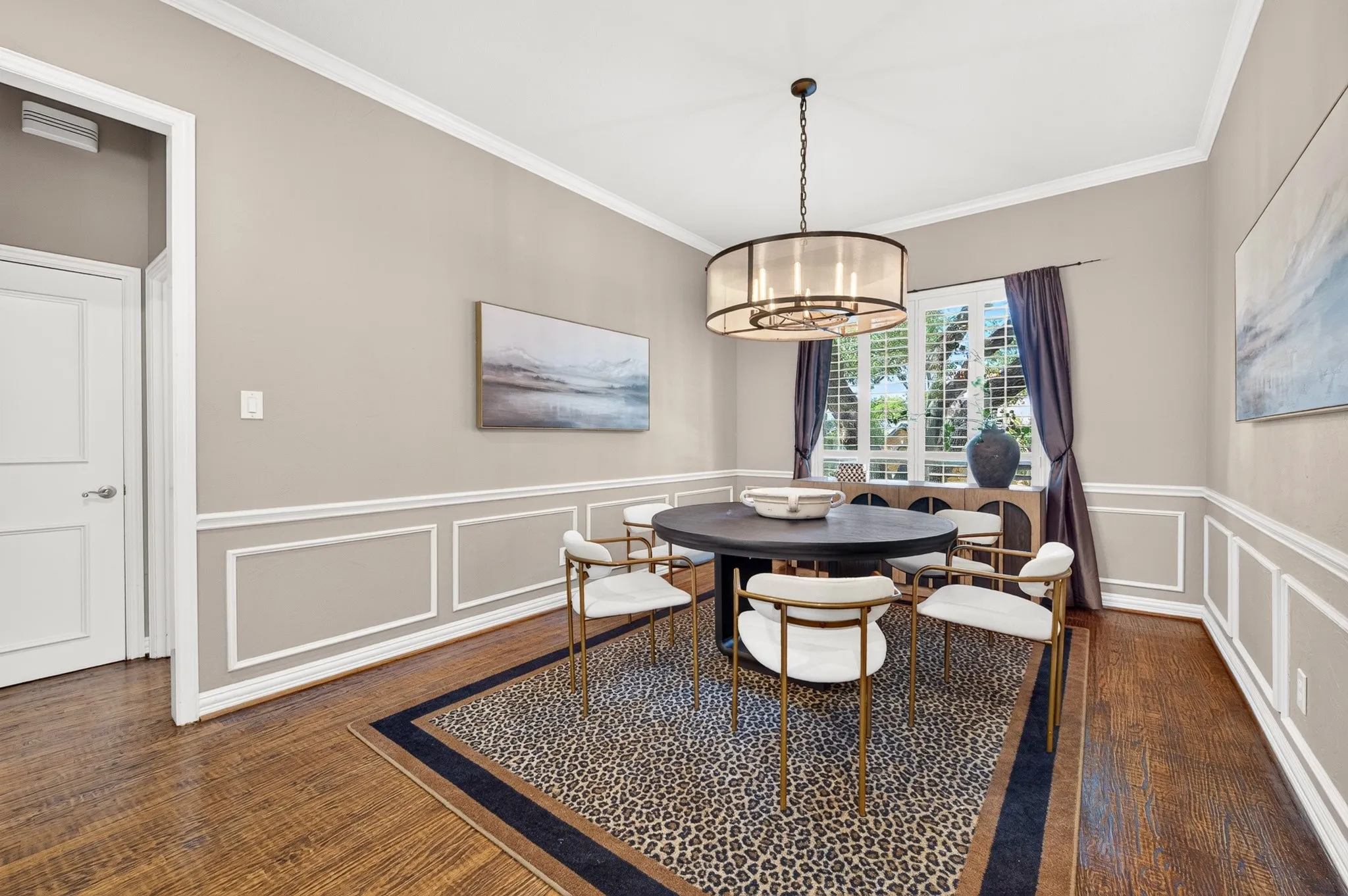 Hardwood flooring, crown molding, wainscoting, and a drum chandelier
