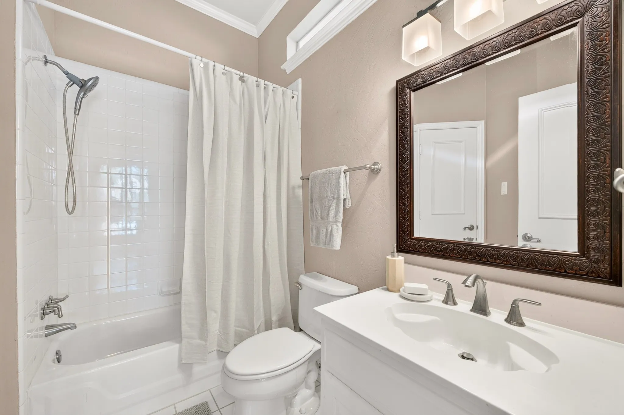 White vanity with integrated sink, brushed nickel faucet, and framed mirror