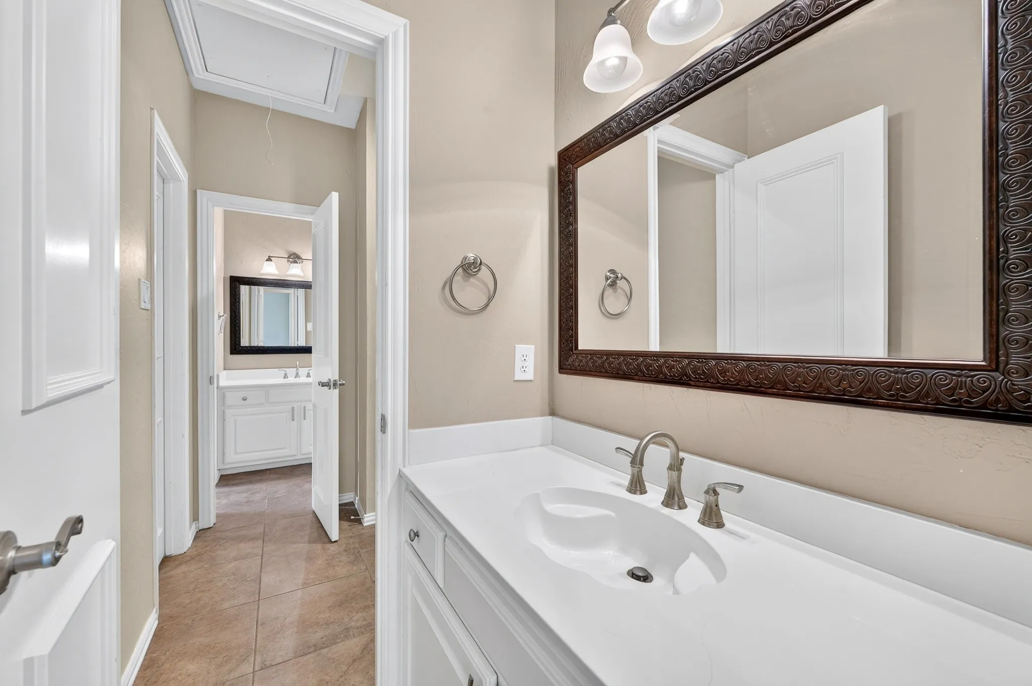 Second floor Jack and Jill bath with white vanity featuring an integrated sink, brushed nickel faucet, and white countertop