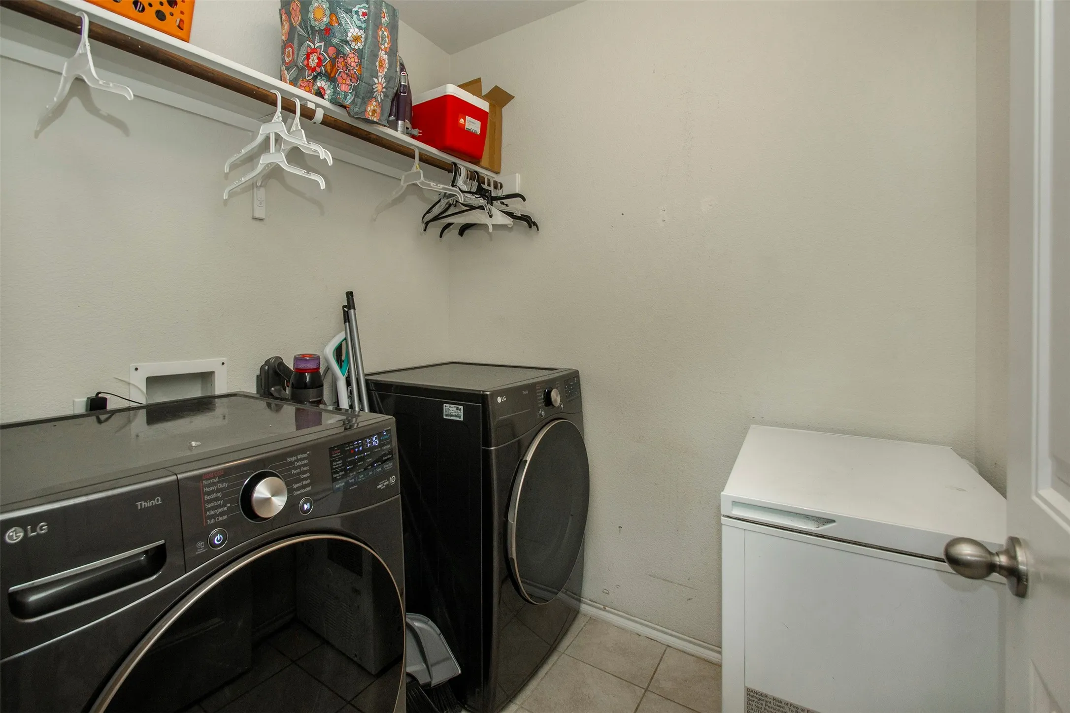 Laundry area with tile flooring and a built-in shelving unit