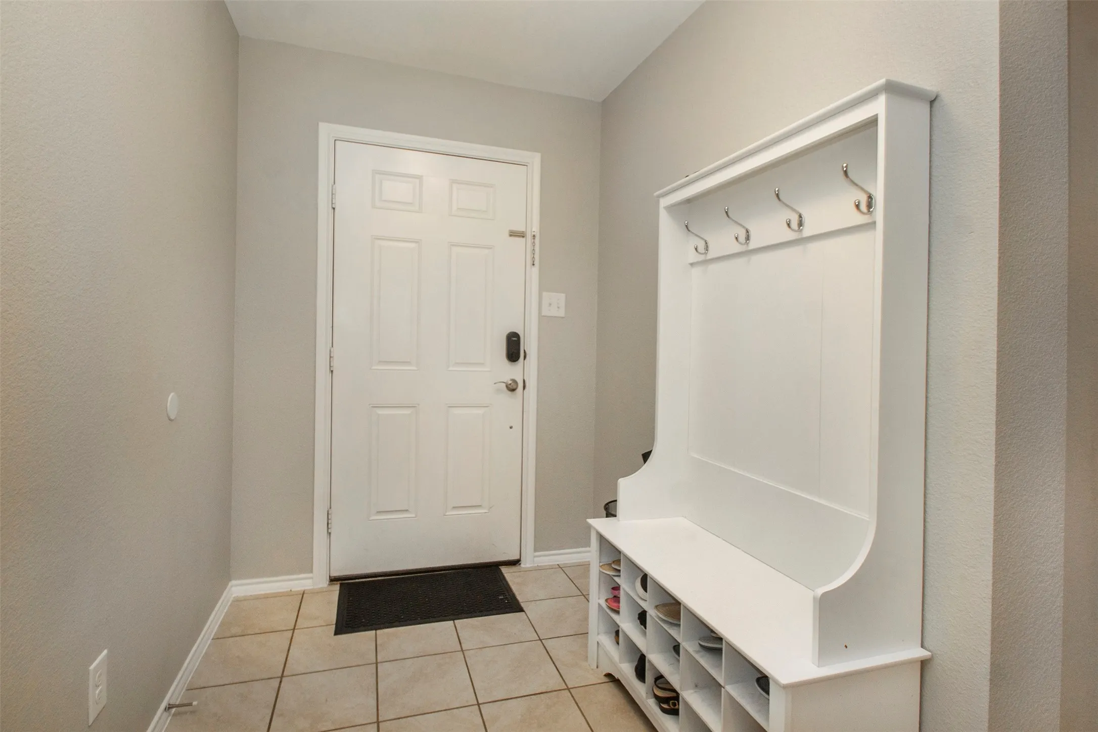 Foyer entry with tile flooring and light gray walls