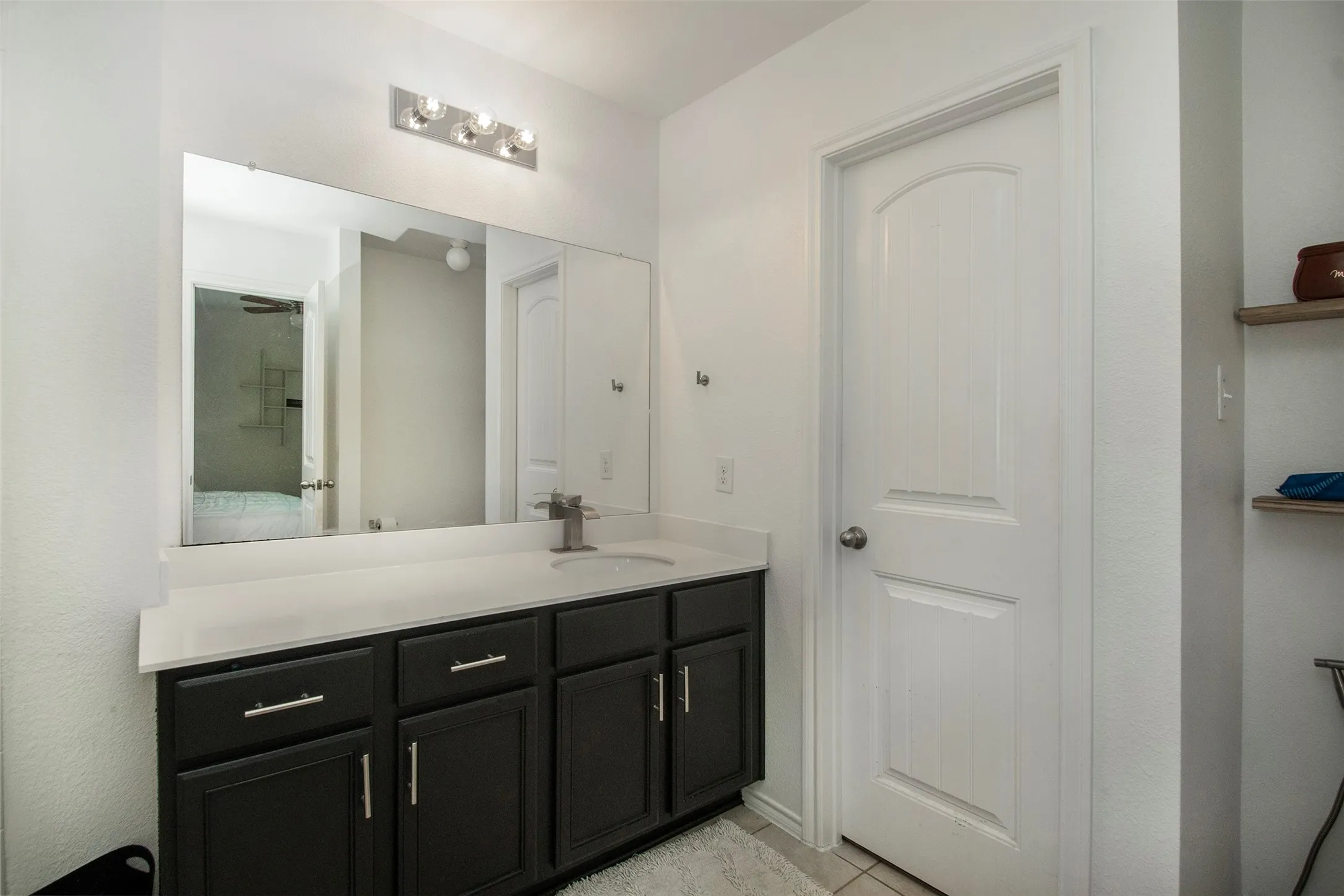 Bathroom vanity featuring a dark finish, white countertop, and rectangular sink with a single-handle faucet