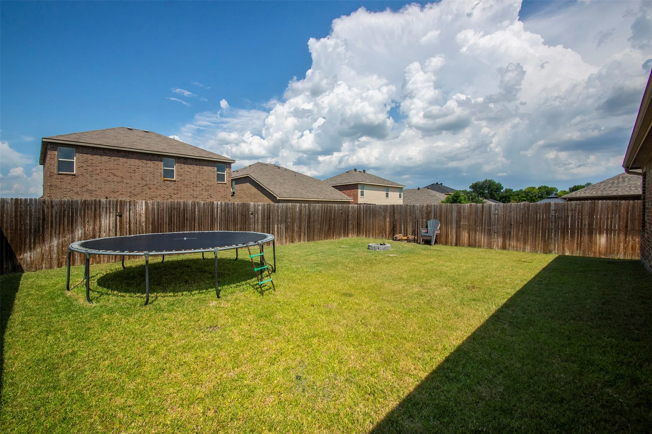 Expansive green lawn with a full privacy fence