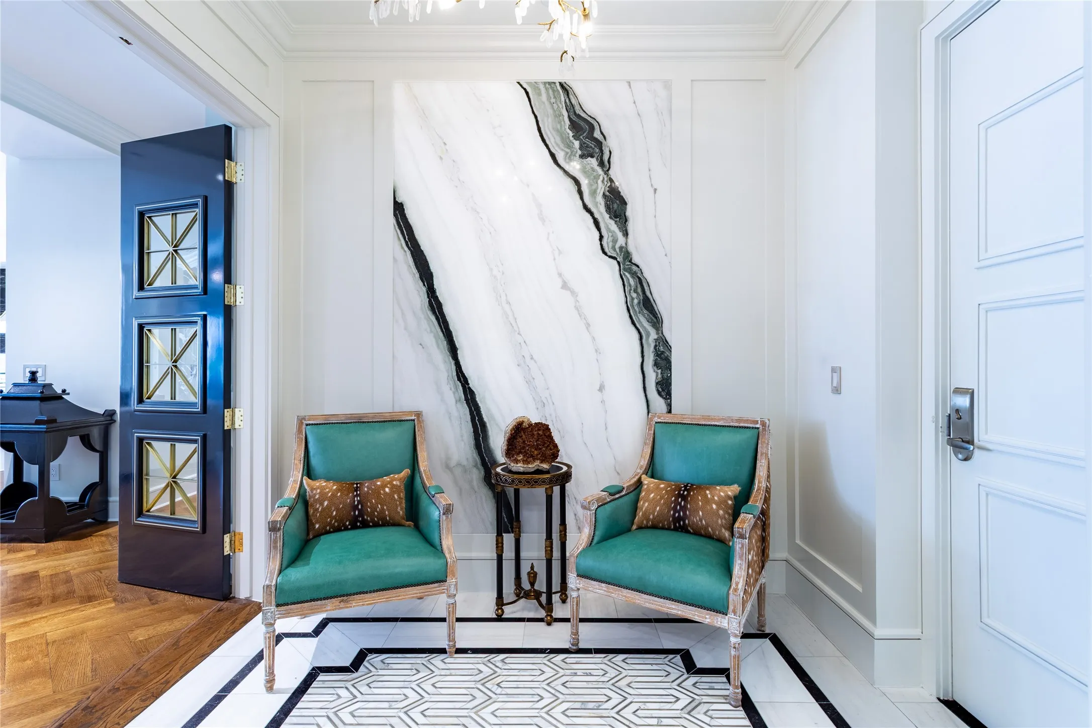 Foyer features a beautiful Panda Stone wall & custom brass-trimmed enamel French Doors.