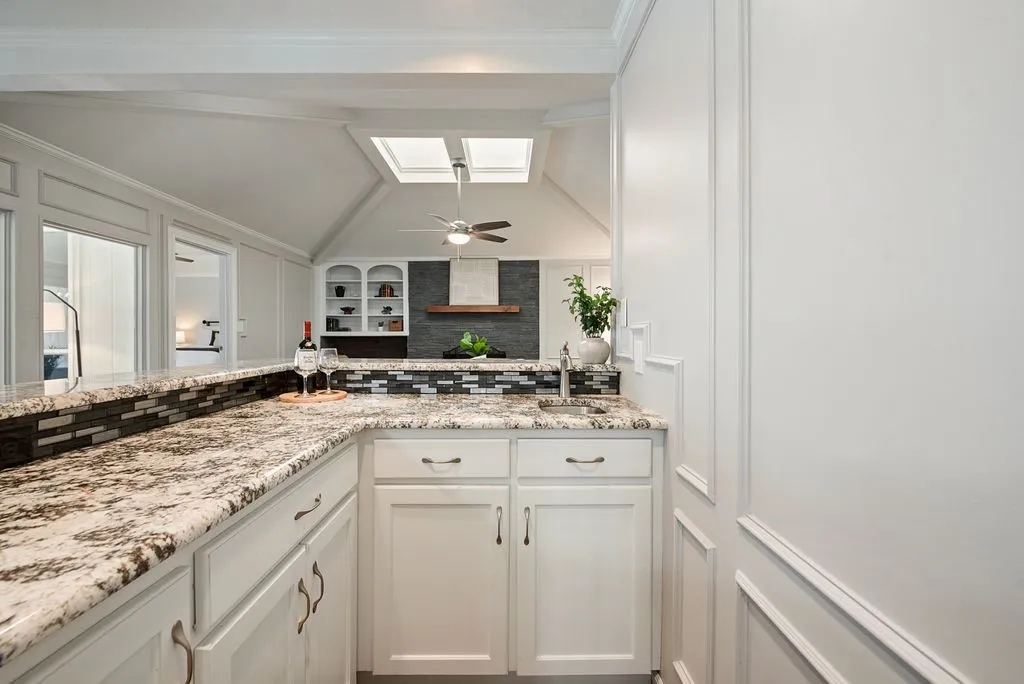 Wet bar featuring granite countertops and cabintry