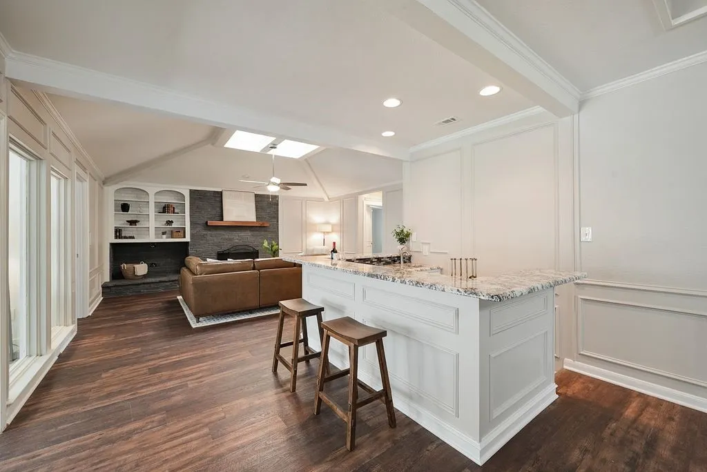 Wet bar with a granite countertops and cabintry