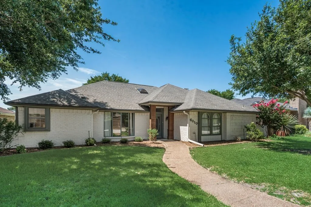 Single-story residence featuring a light brick exterior with dark trim windows