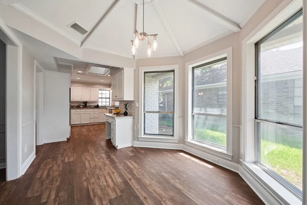 Dining area with high ceilings and a view of the kitchen