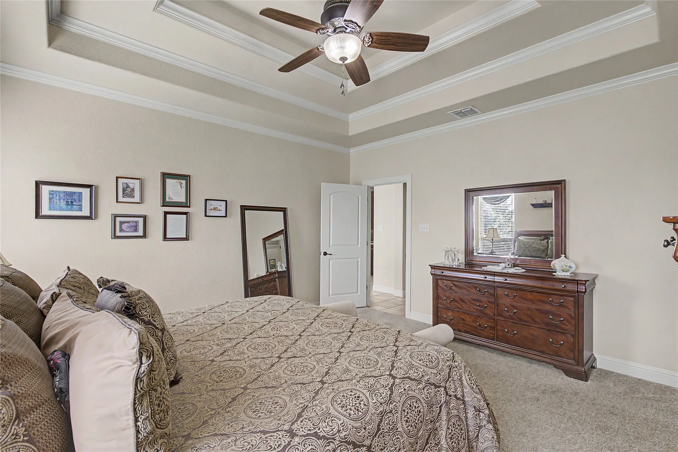 Spacious primary bedroom with plush carpet