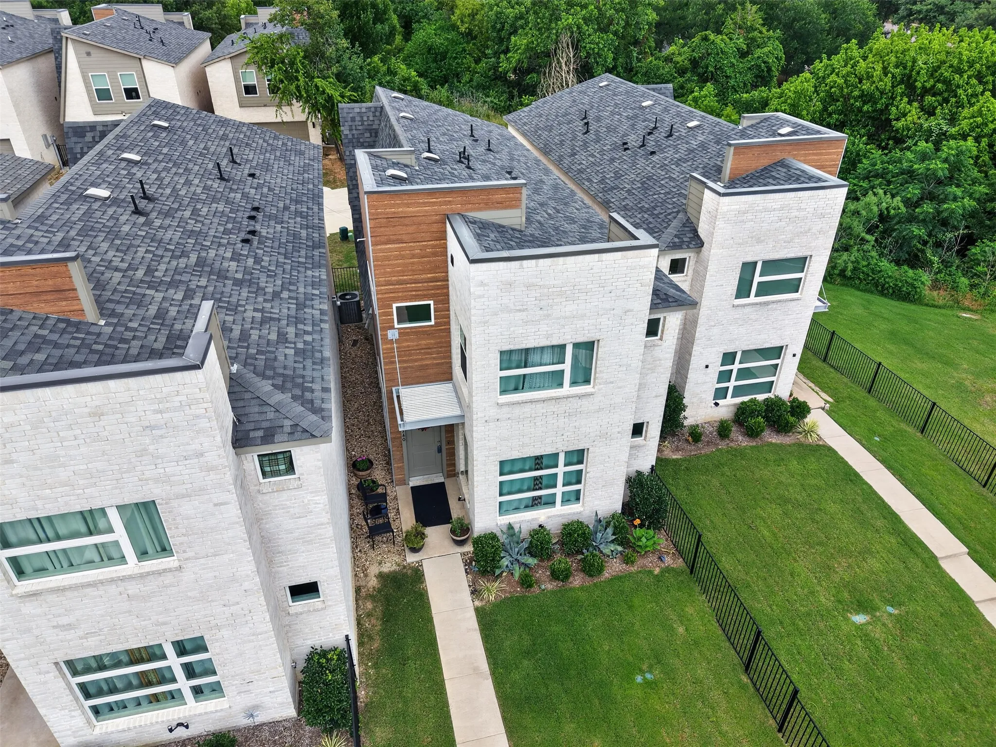 Modern townhome featuring white brick and wood siding