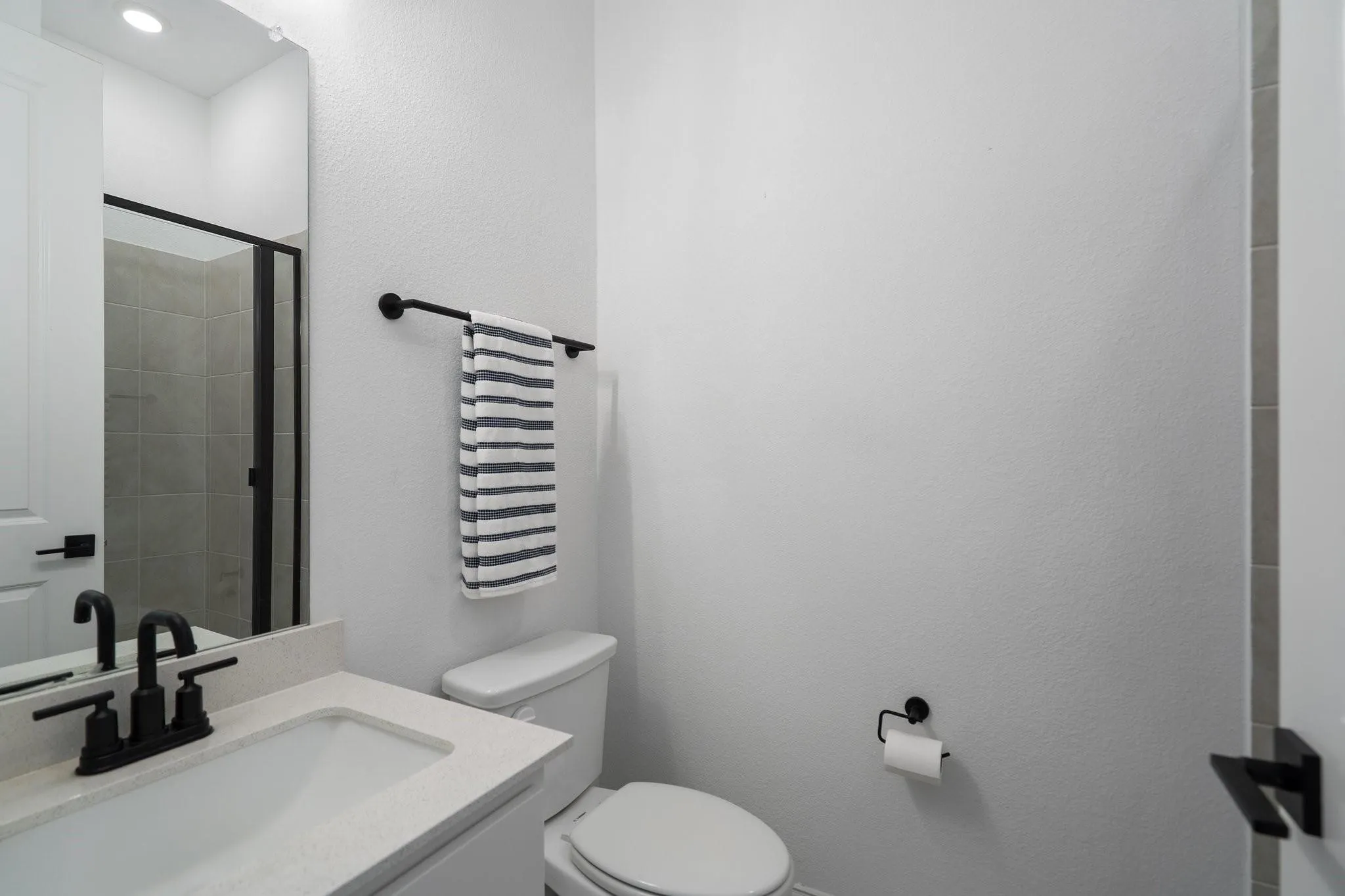 Parent's Bathroom featuring a vanity with a light-colored countertop, an undermount sink, and a black faucet