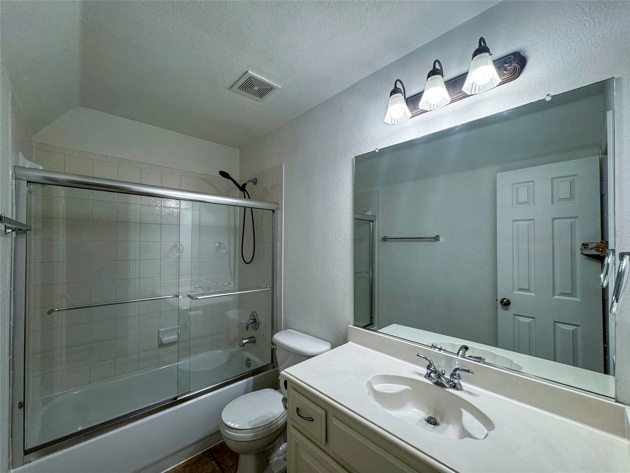Tub-shower combination with sliding glass doors and tiled surround