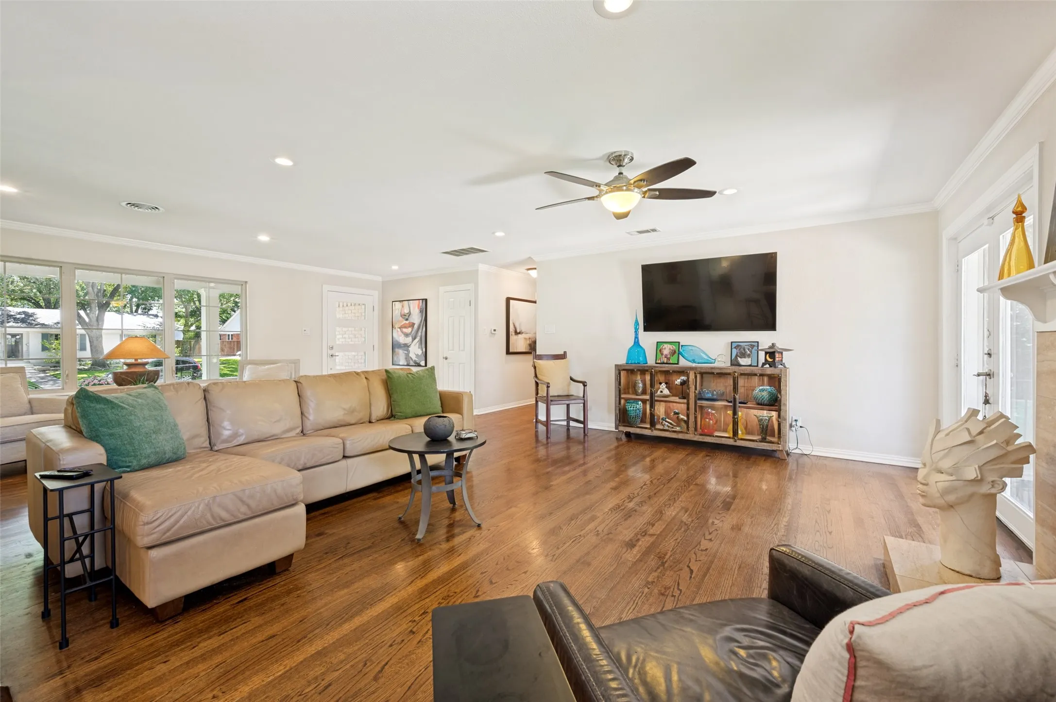 Bright living space featuring wood flooring, recessed lighting, and a ceiling fan with integrated lighting
