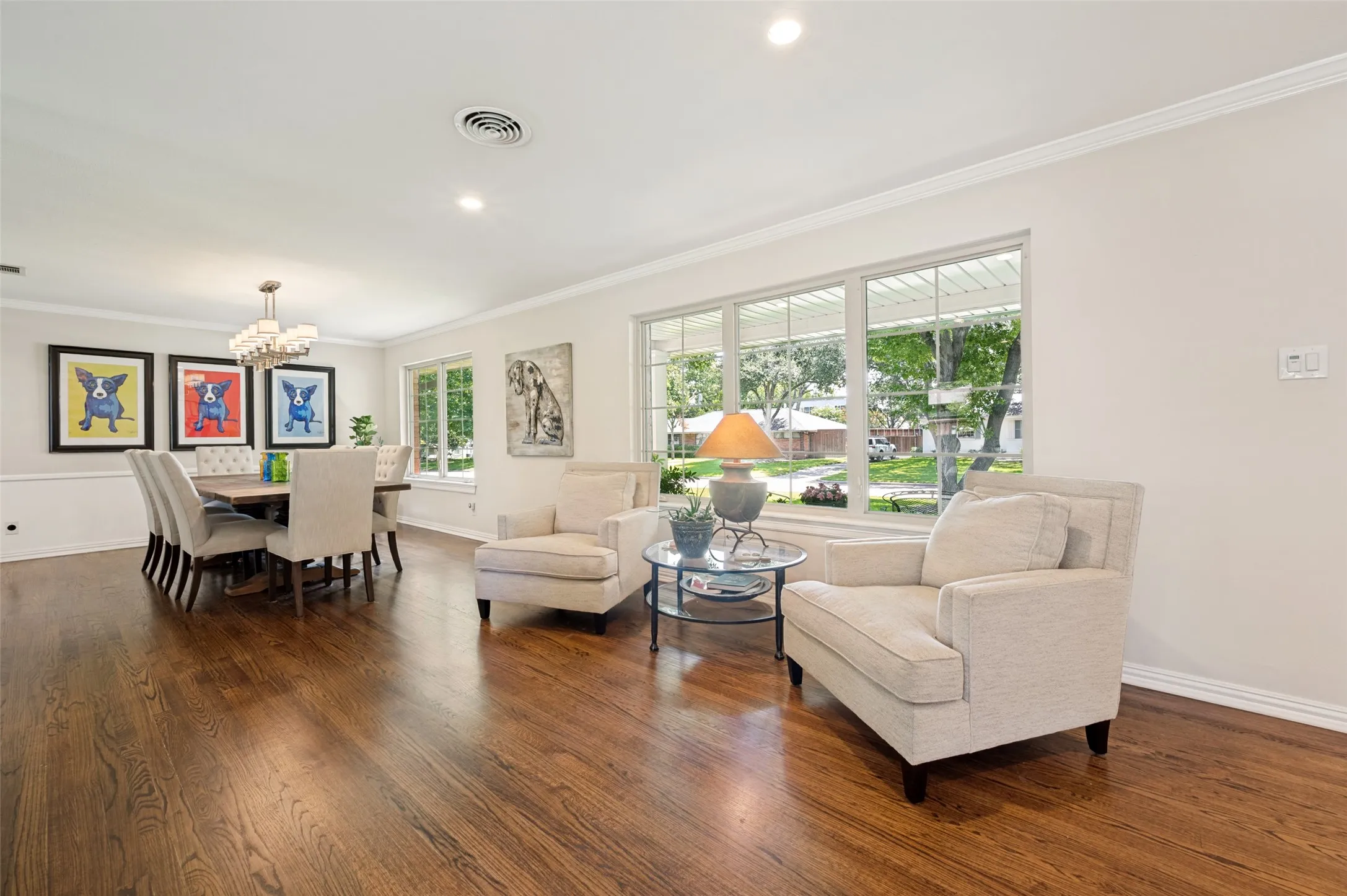 The front living area into the dining area with large picture windows and wood floors
