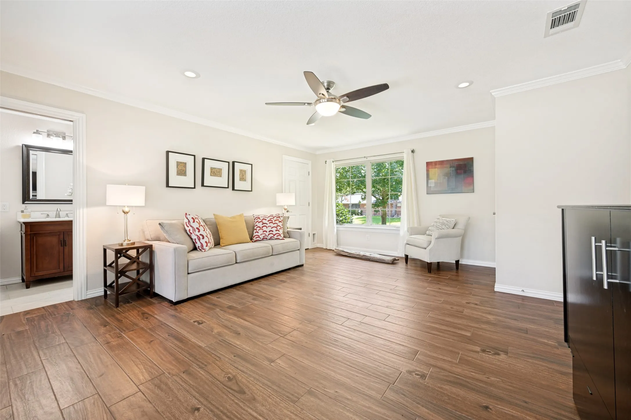 Spacious living area featuring wood flooring, recessed lighting, and a ceiling fan