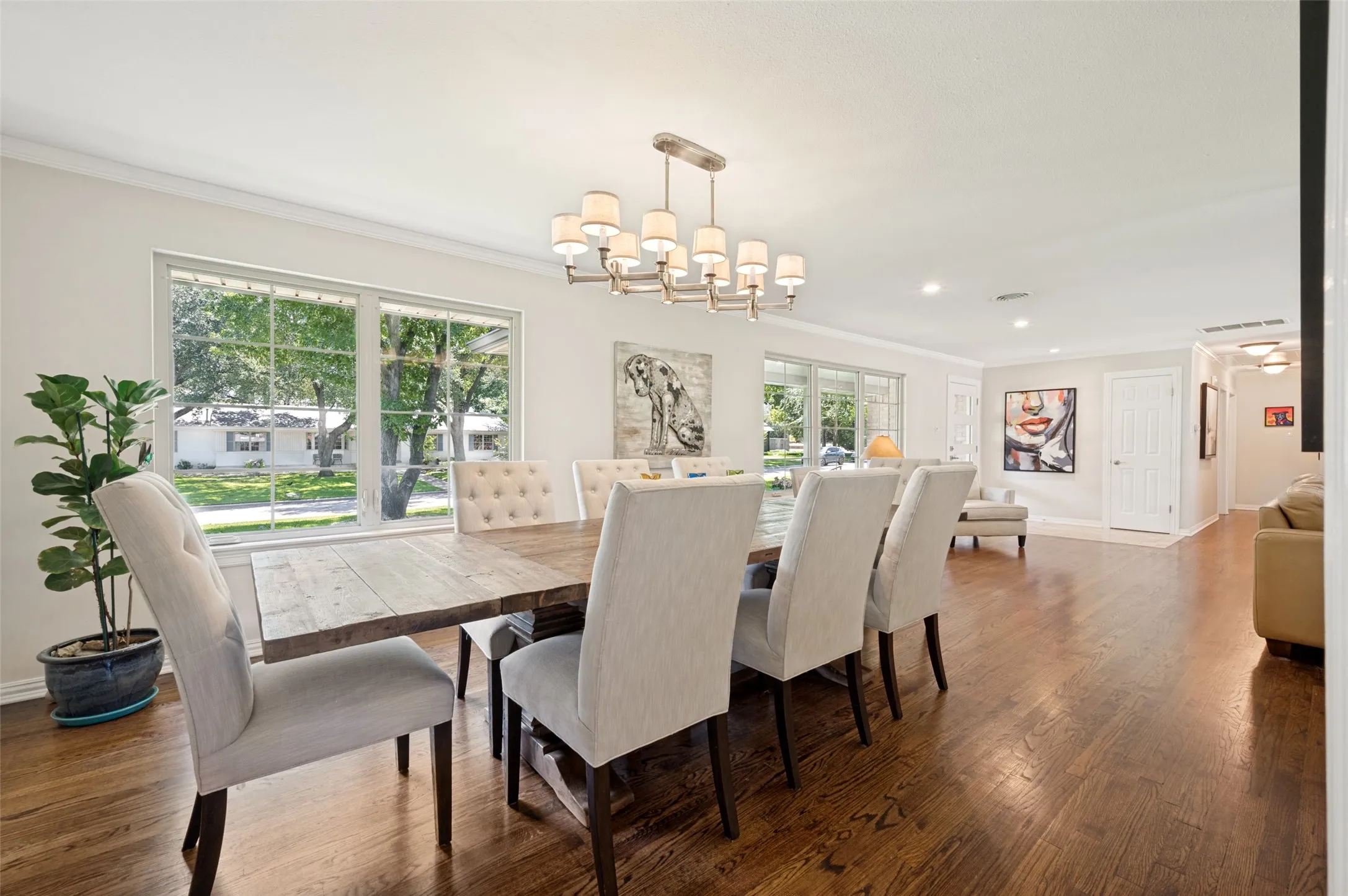 Spacious dining area featuring wood flooring, two large windows, recessed lighting, and a multi-arm chandelier