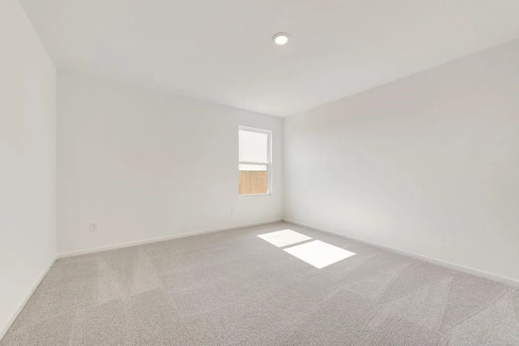 Spare room featuring carpet and baseboards