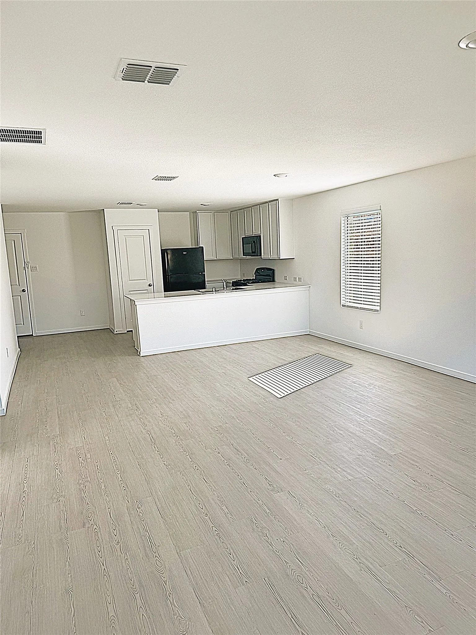 Unfurnished living room with light wood-style flooring and baseboards