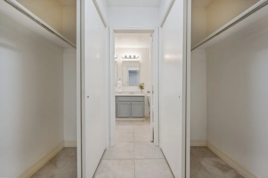 Entryway featuring two open closet spaces with bi-fold doors and carpet flooring
