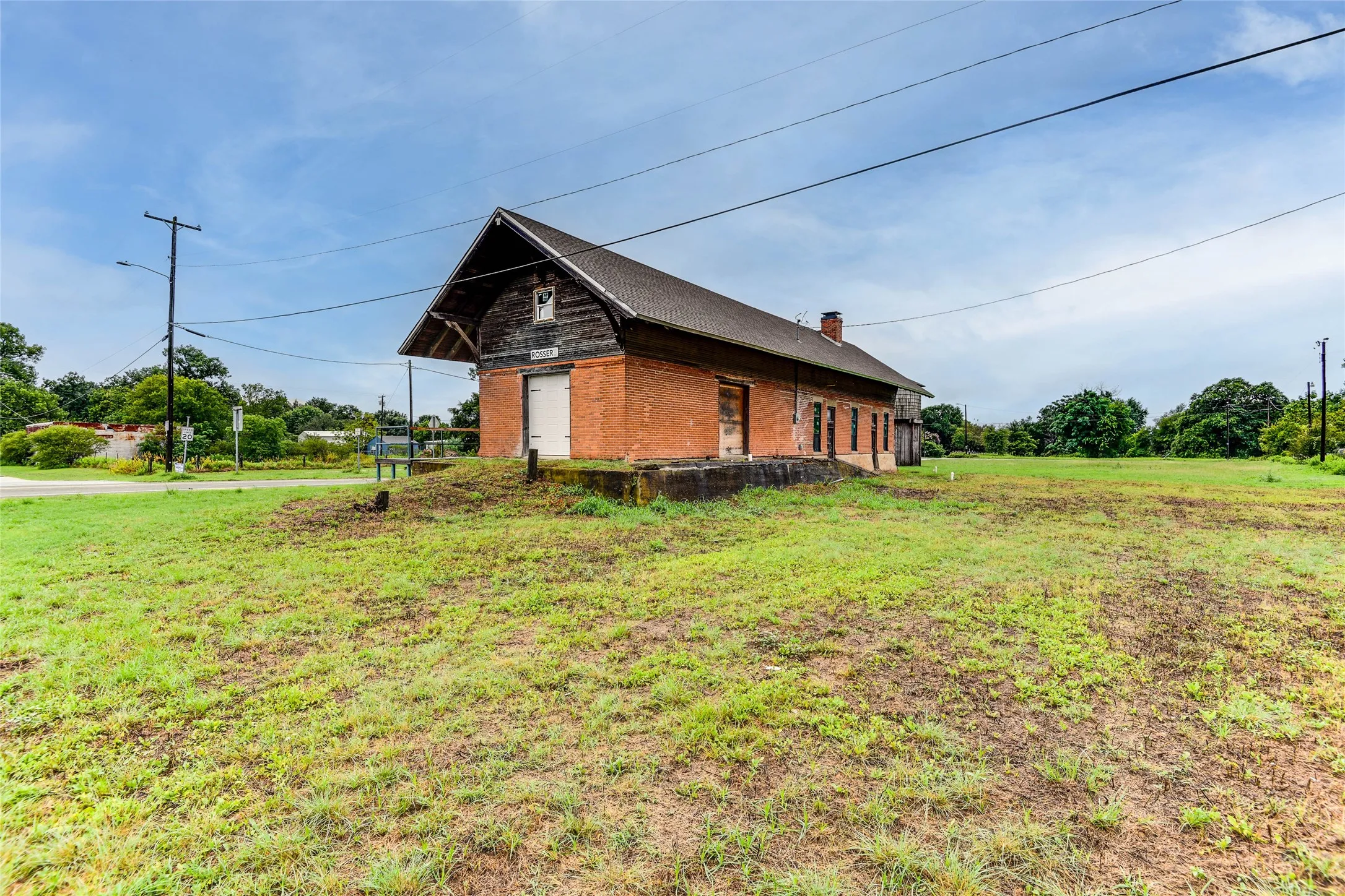 View of property exterior with a chimney and a lawn