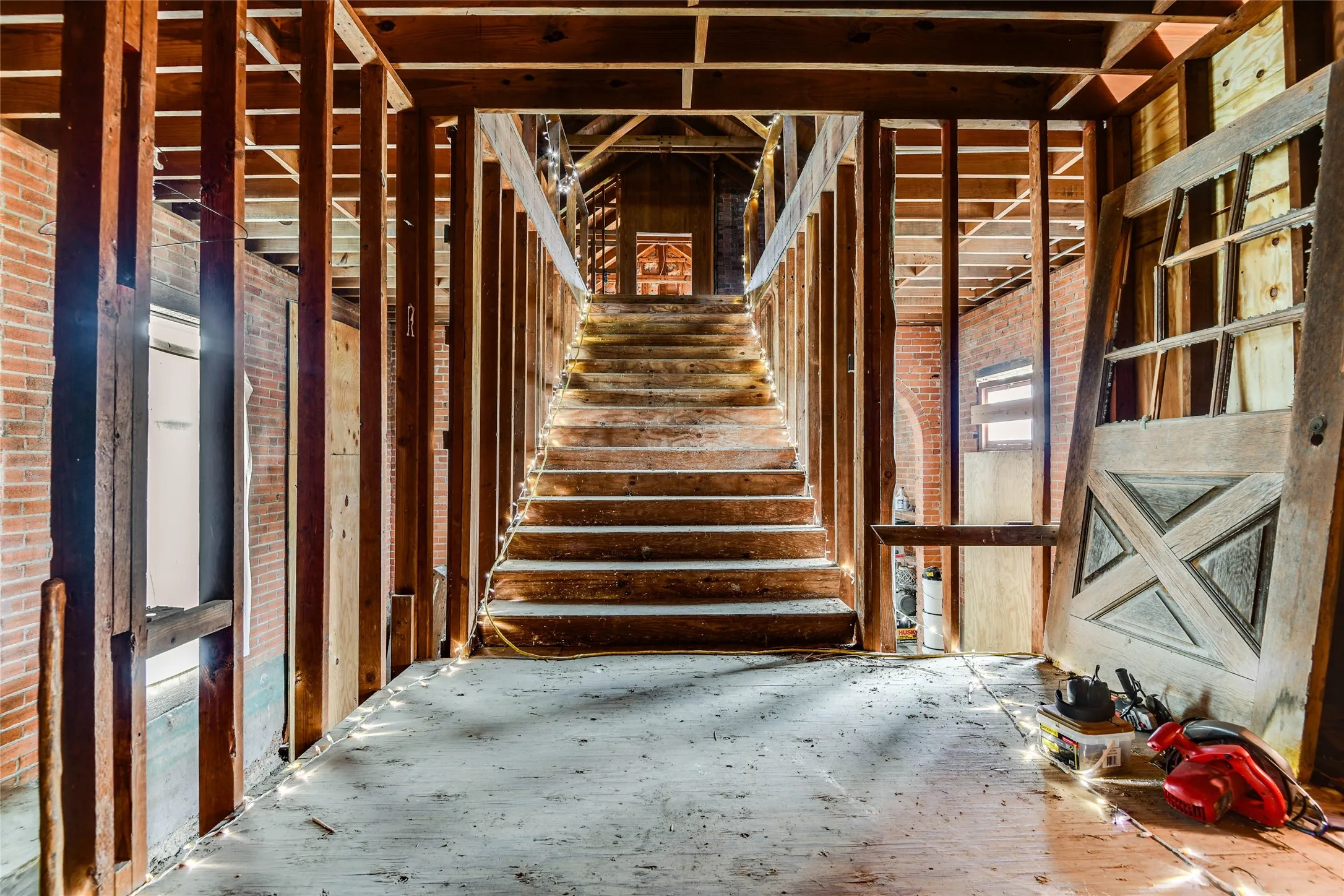 Misc room with brick wall and stairway