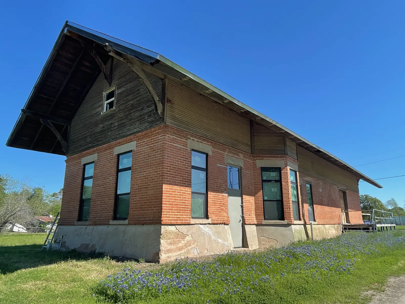 View of side of property with a lawn and brick siding