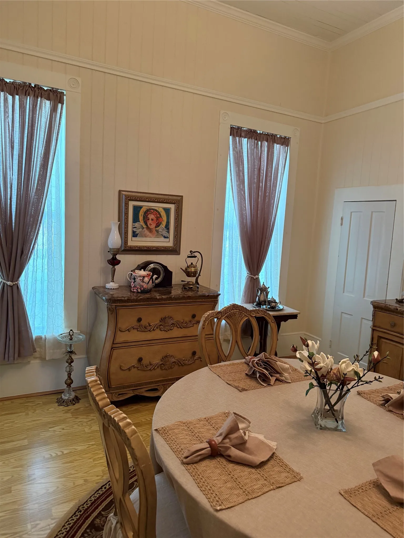 Dining area with wood-finish flooring, two window openings, and crown molding