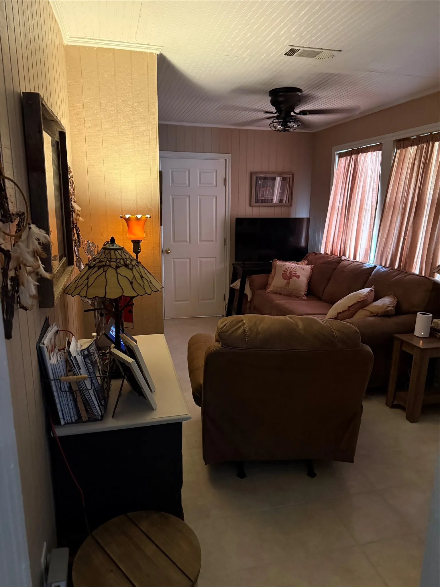 Living area featuring horizontal paneling and a beadboard ceiling