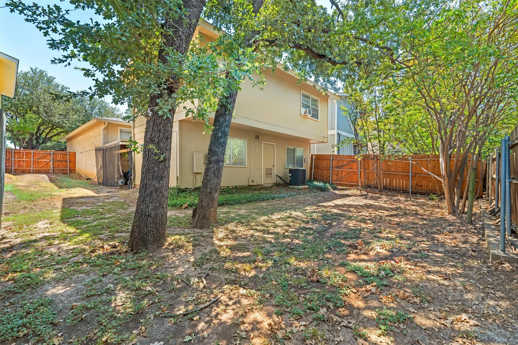 Private backyard with a wood fence and mature trees