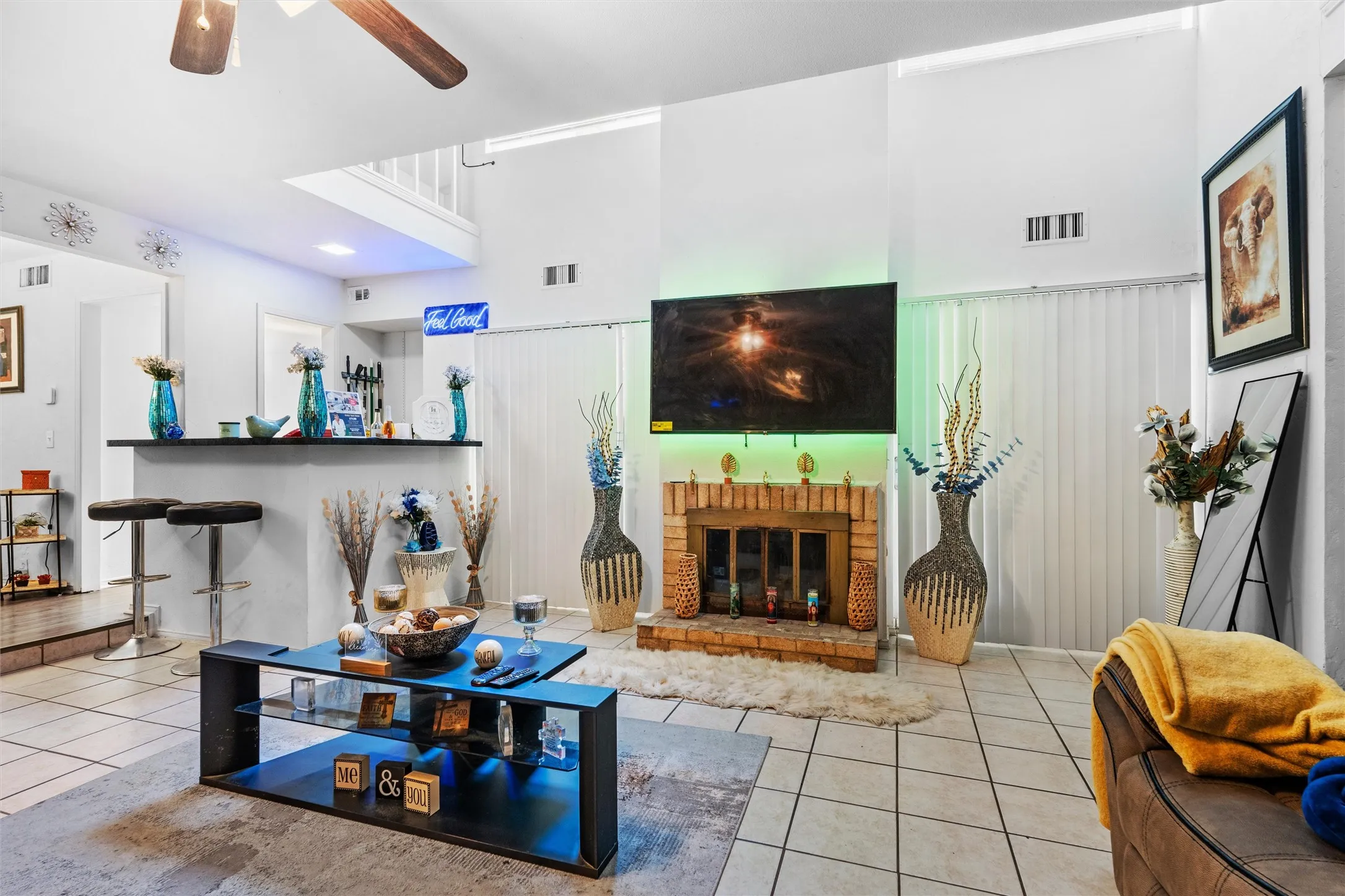 Vaulted ceilings, tile flooring, brick fireplace, and a built-in wet bar with a countertop