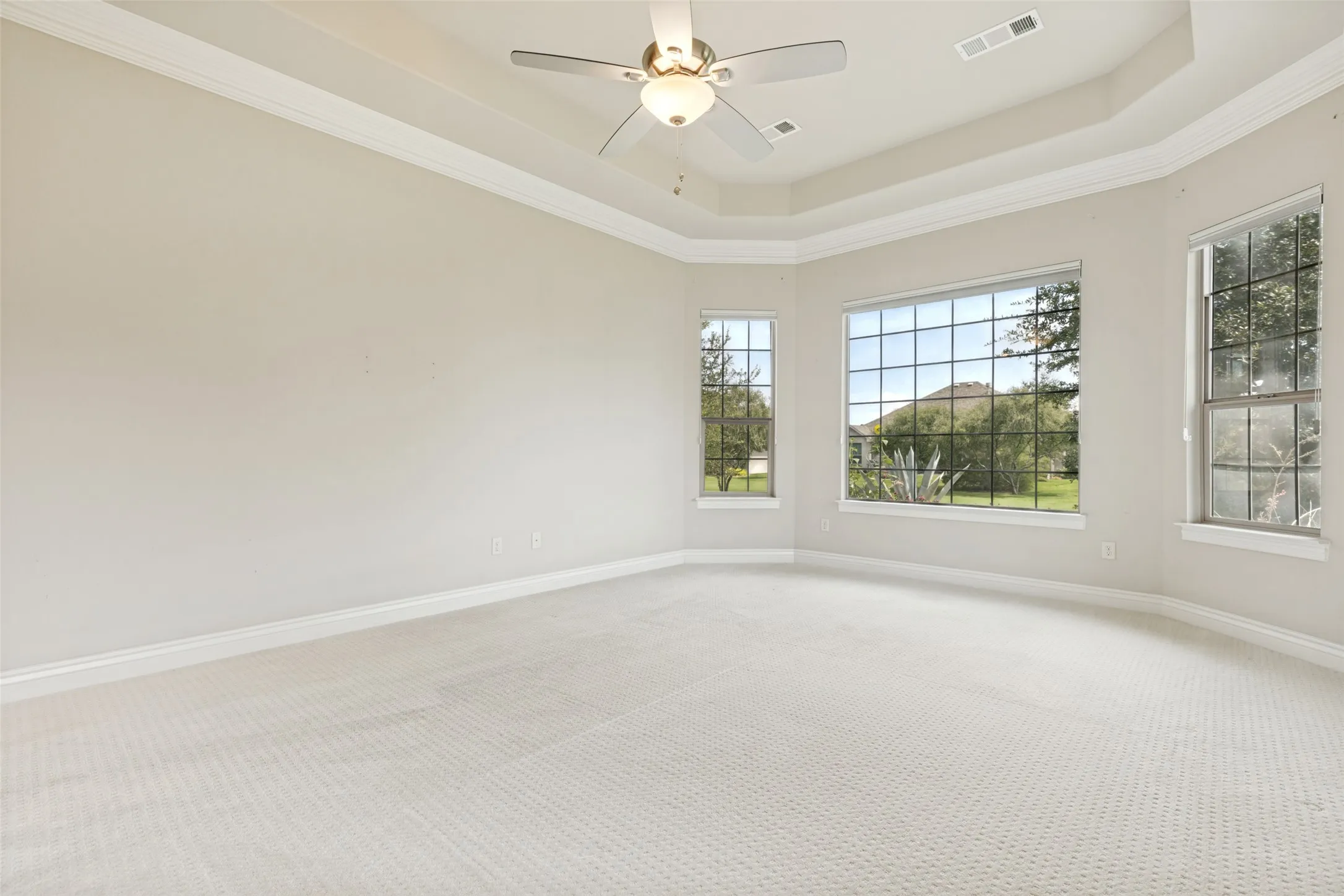 Expansive room featuring light-toned carpeting and multiple large windows