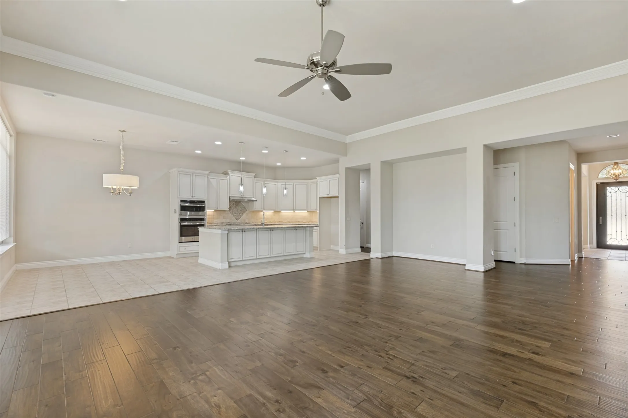 Spacious living area featuring wood-finish flooring, recessed lighting, and a ceiling fan