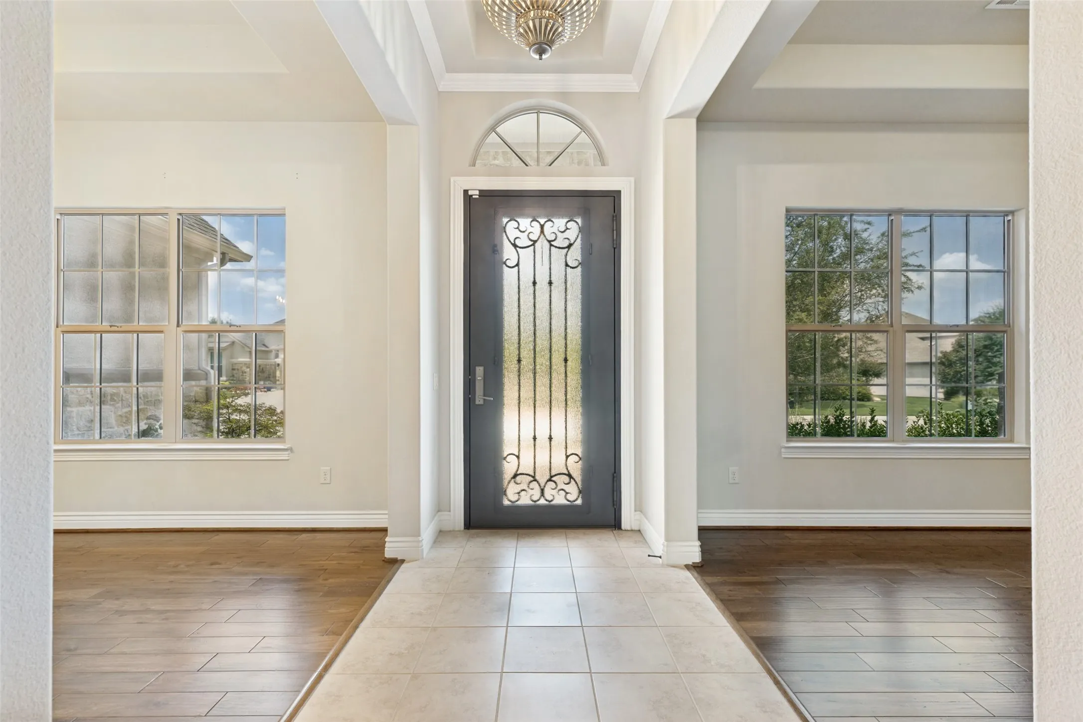 Grand entryway featuring a decorative iron and glass front door with an arched​​‌​​​​‌​​‌‌​‌‌​​​‌‌​‌​‌​‌​​​‌​​ transom