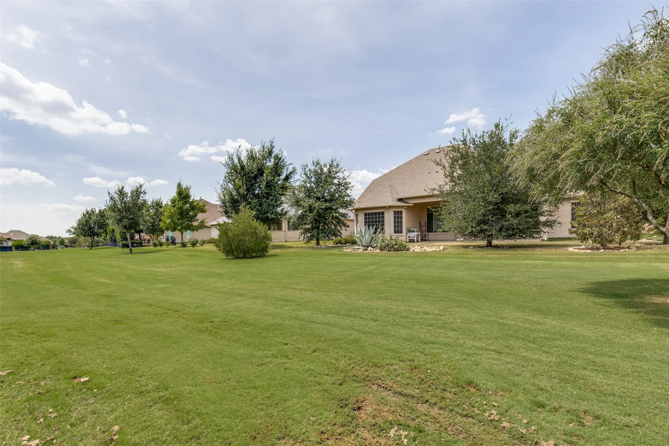 Expansive lawn with mature trees and landscaping