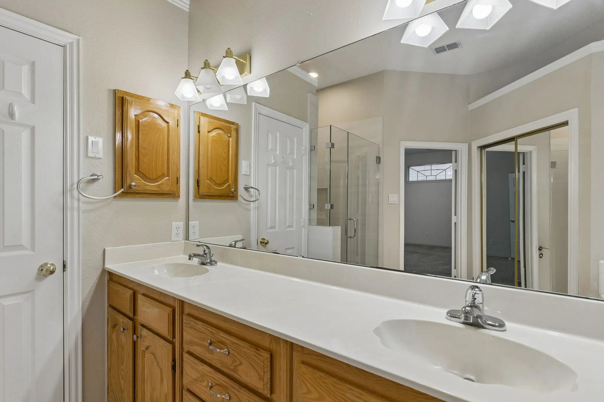 Primary Bathroom with tall cabinet and dual sinks.