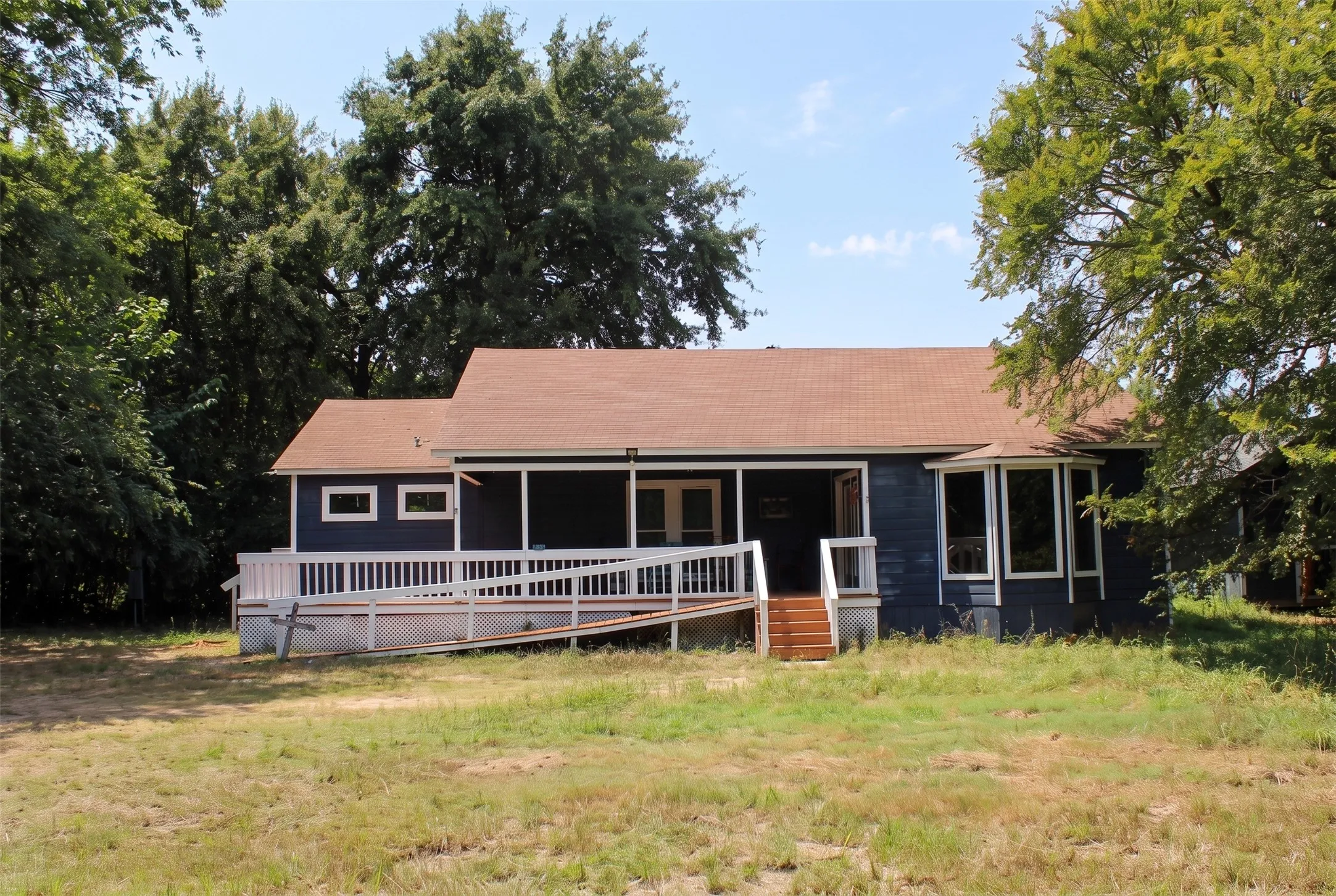 Single-story residence featuring a blue exterior, a covered front porch, and a bay window