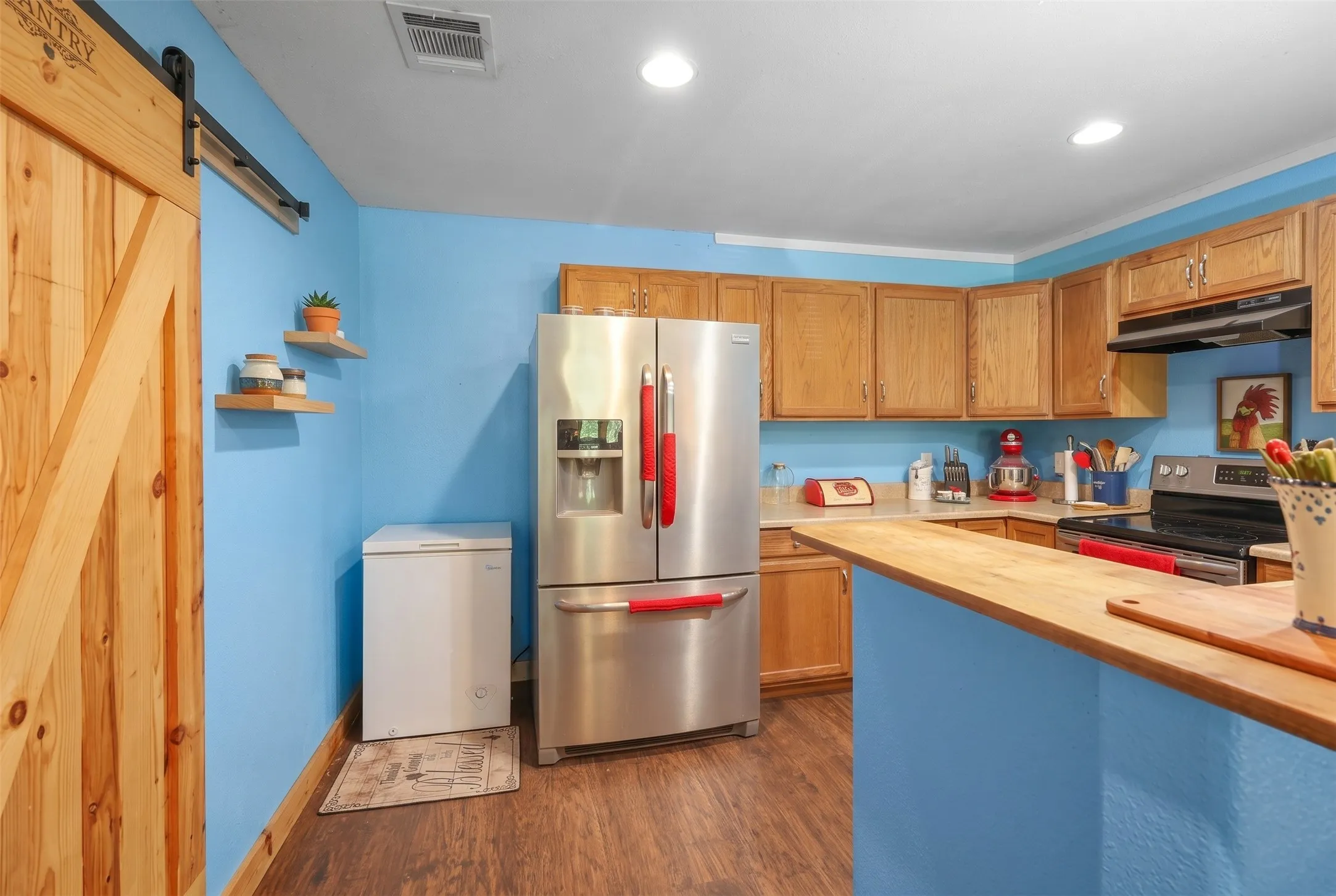 Kitchen featuring wood-finish flooring, custom wood cabinetry, and wood countertops