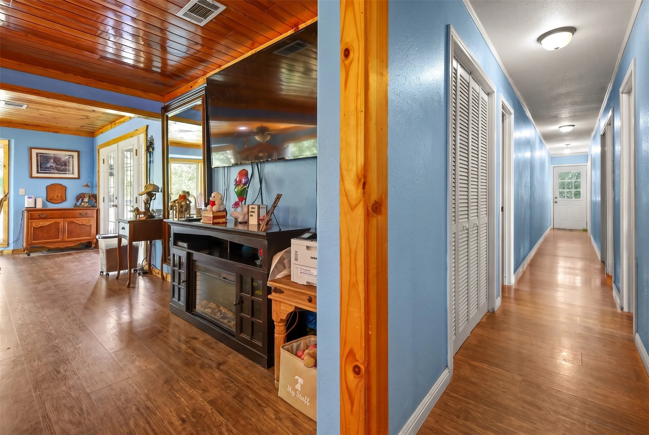 Interior space featuring wood-finish flooring, a wood-paneled ceiling, and light blue walls