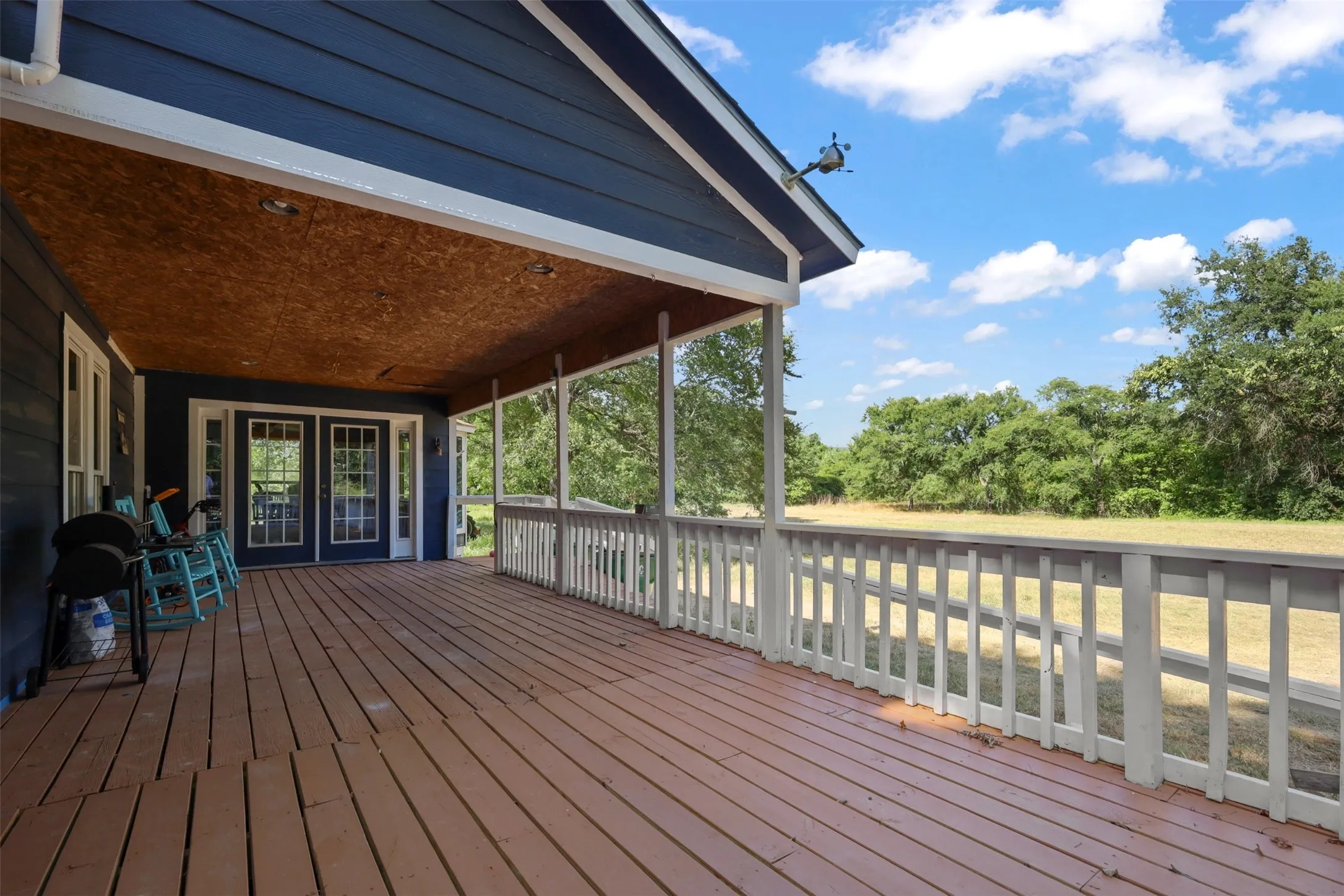 Spacious covered deck featuring wood-finish flooring and a white railing system