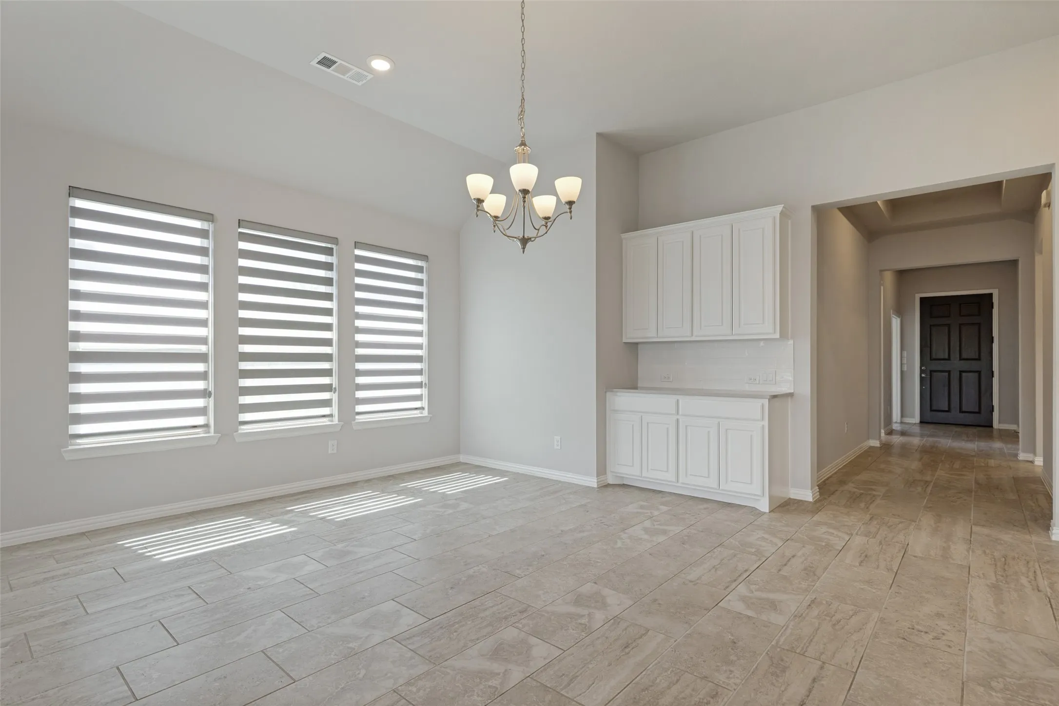 Bright dining area with soaring ceilings and built-in buffet