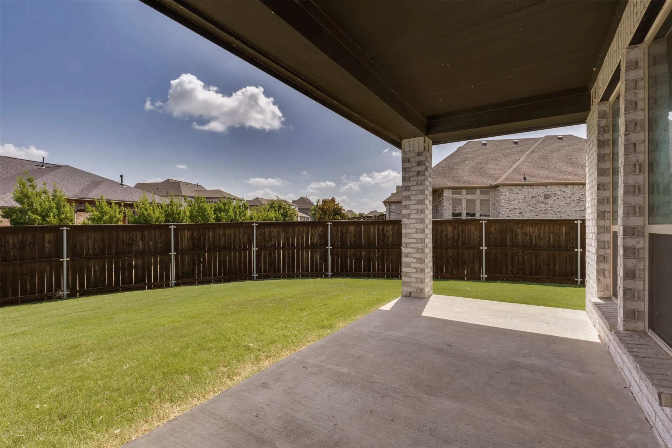 Covered patio featuring a concrete surface and brick columns