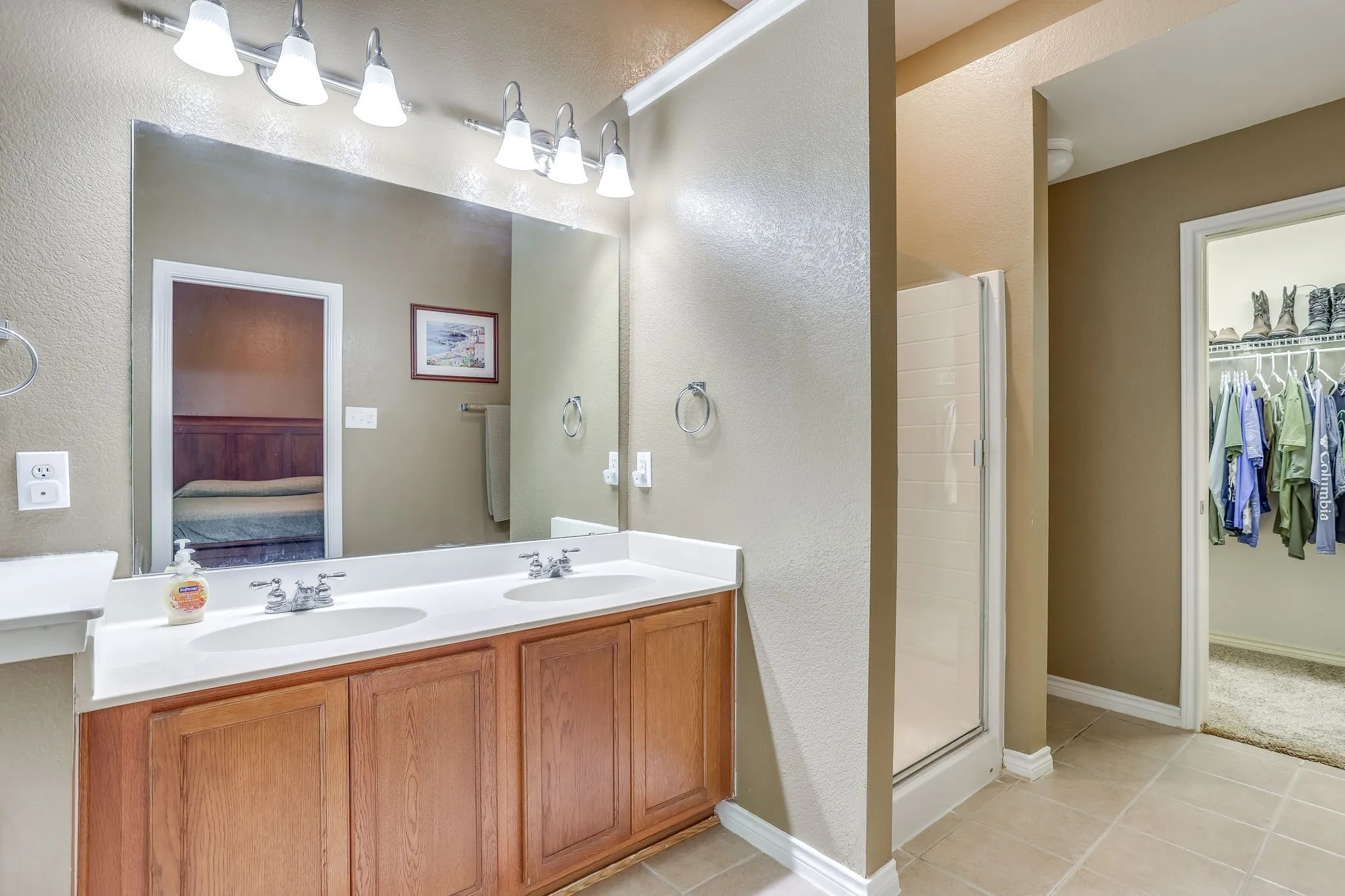 Primary Bathroom with double sinks separate shower and walk in closet