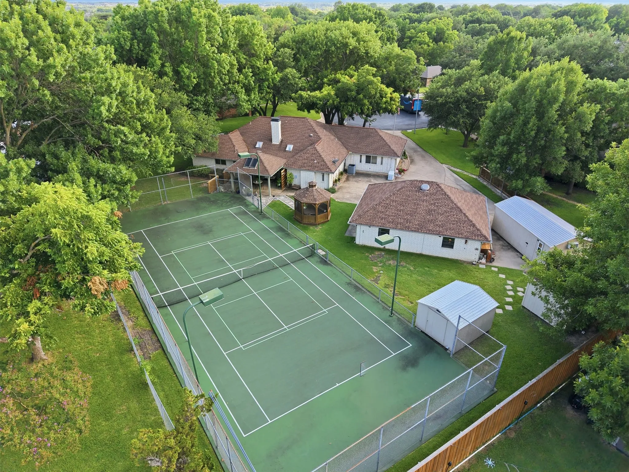 Expansive green tennis court with perimeter fencing
