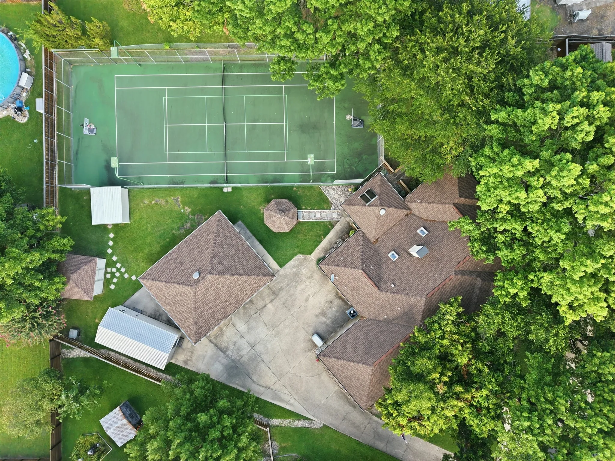 Expansive property featuring a private tennis court, and multiple outbuildings