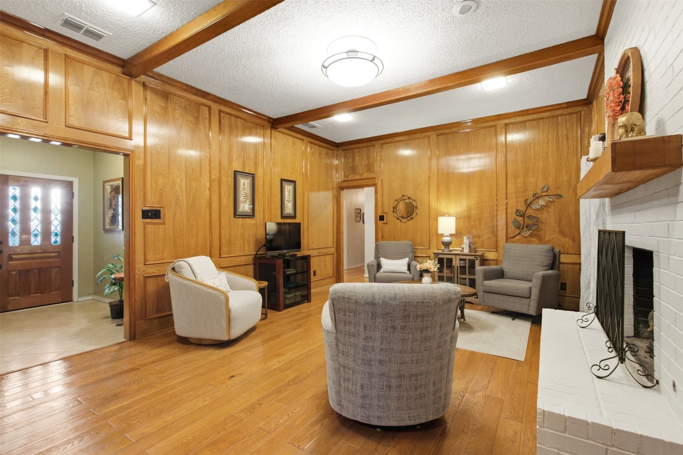 Paneled walls and wood-finish flooring define this living space
