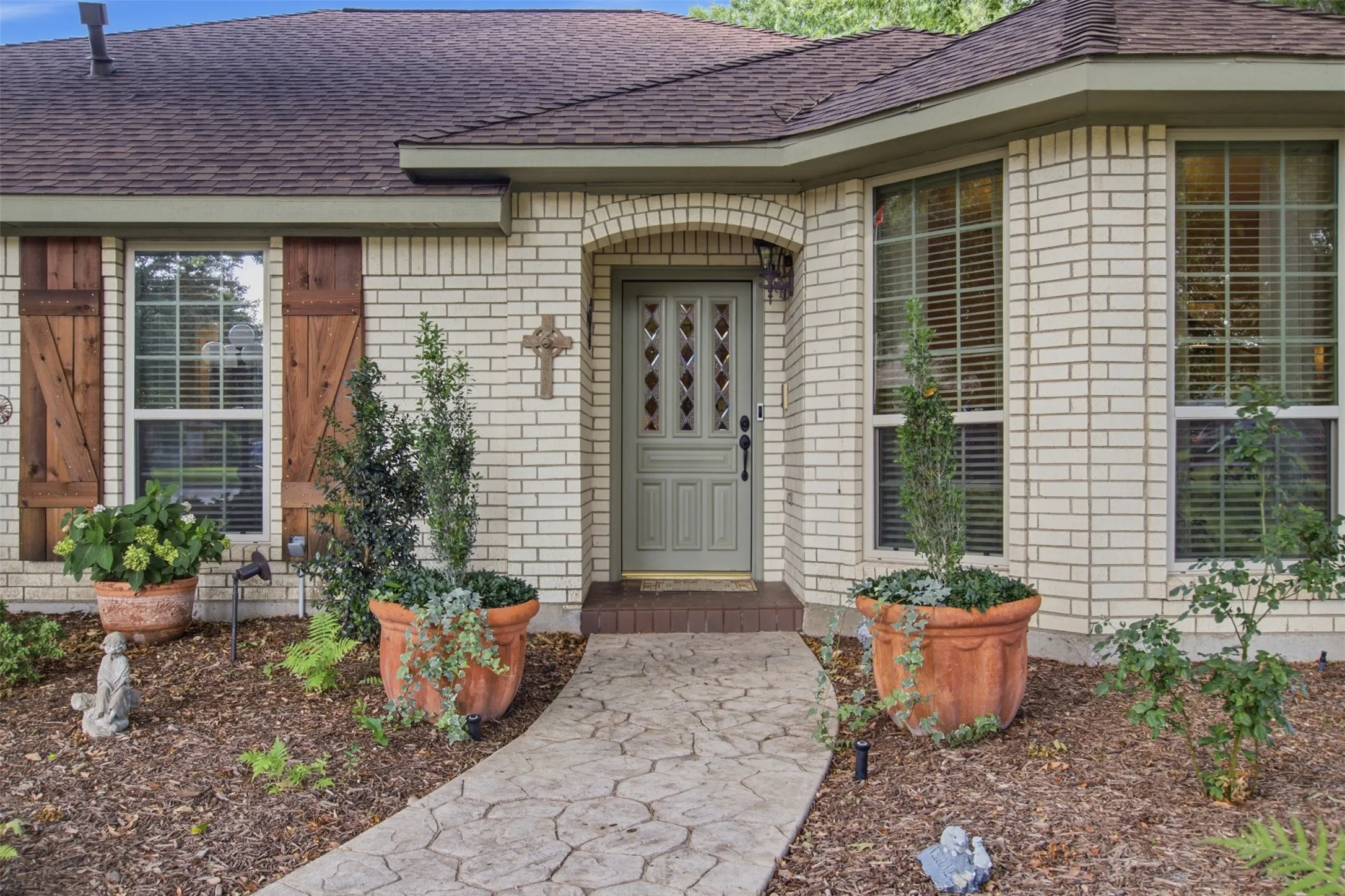 Light-colored brick exterior featuring a multi-pane front door with an arched entryway