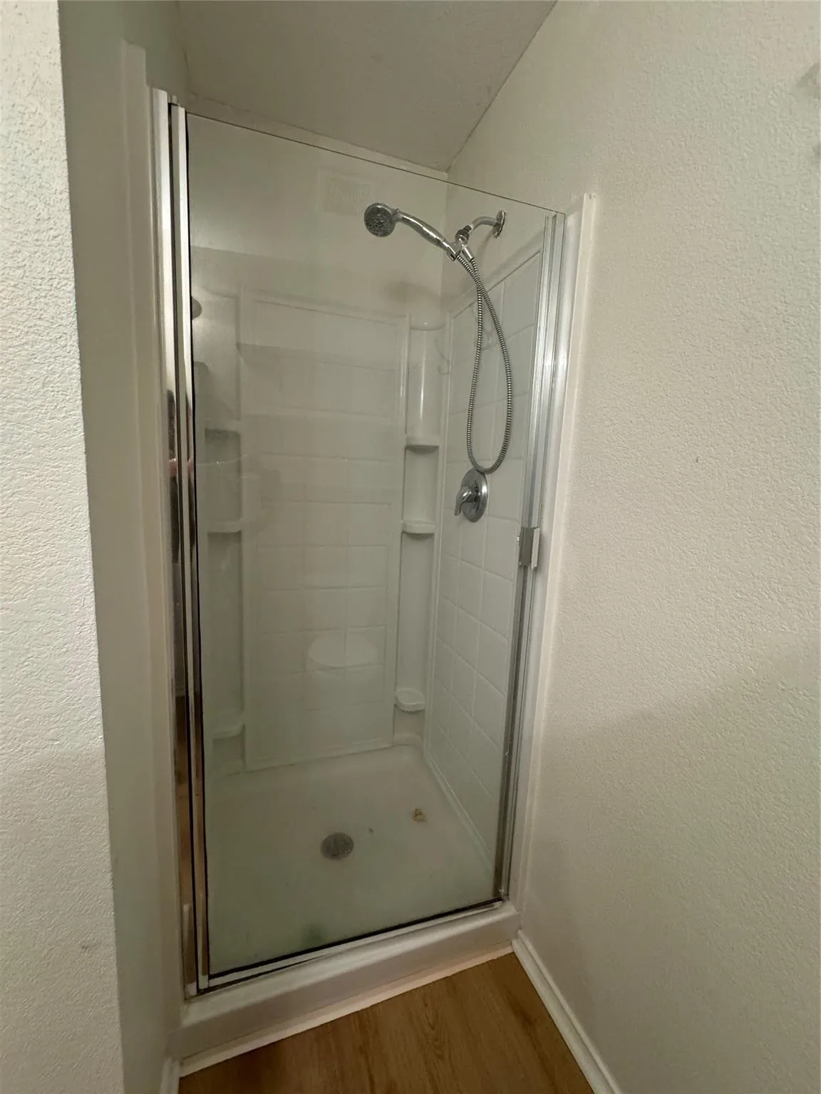 Corner shower enclosure featuring clear glass panels and chrome hardware
