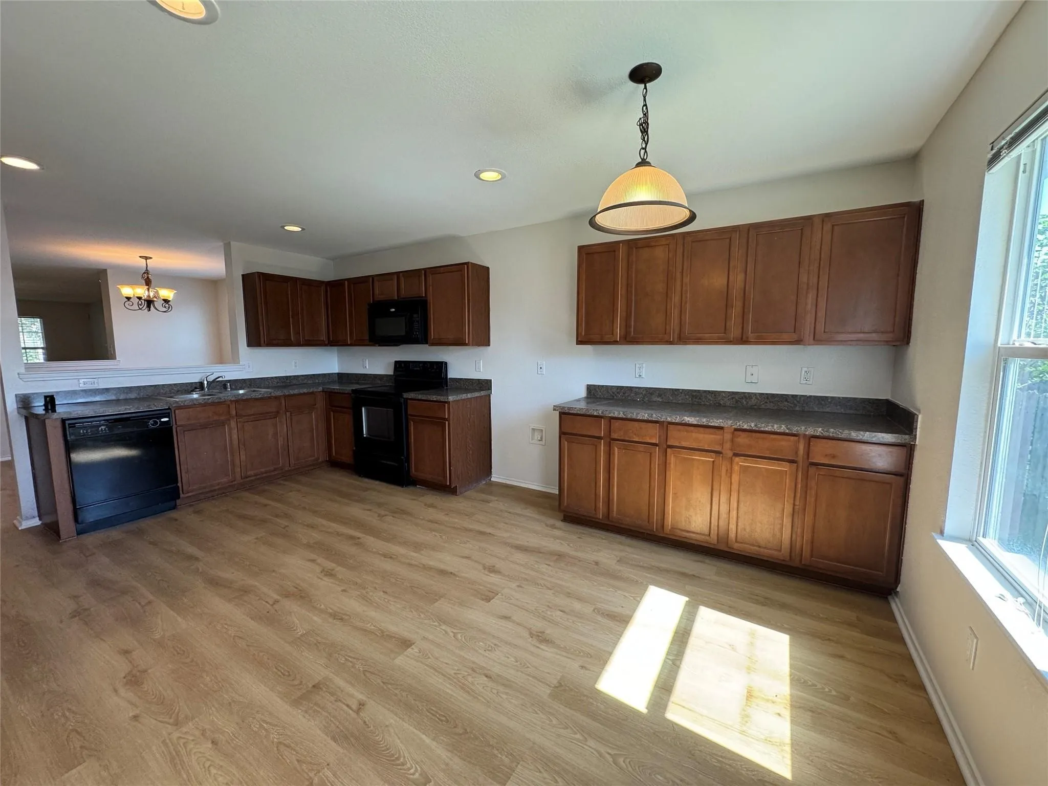 Kitchen featuring wood-finish flooring, dark wood cabinetry, and speckled countertops