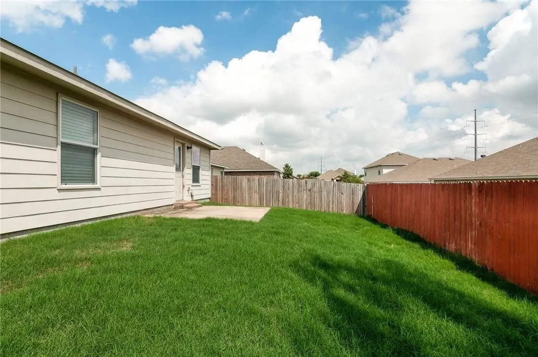 Expansive grassy yard with a concrete patio